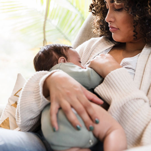 black mom holding breastfeeding baby